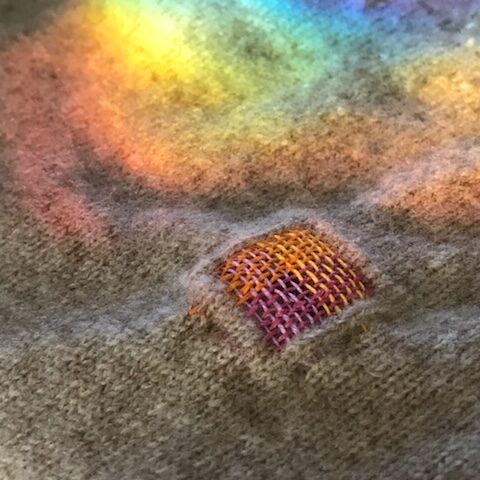 Creatively mended fabric with a prism rainbow